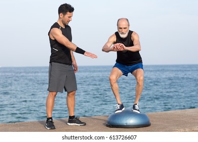 Senior Man Making Exercise On Balance Platform By The Sea