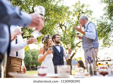 A Senior Man Making Speech At Wedding Reception Outside In The Background.