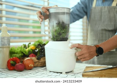 Senior man making vegetable smoothie with fresh vegetables in a blender. Healthy eating lifestyle concept - Powered by Shutterstock