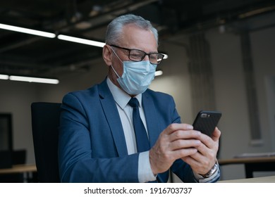 Senior man in medical mask using mobile phone, communication, searching online, working from home. Coronavirus, social distance, stay at home concept - Powered by Shutterstock