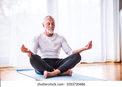 Senior man meditating at home.