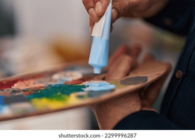 Senior man mixing color on palette at art studio - Powered by Shutterstock