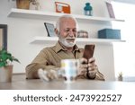 Senior man, morning coffee and phone looking happy while reading text message, online news or browsing internet in kitchen at home. Male using messenger or social media mobile app in his house.