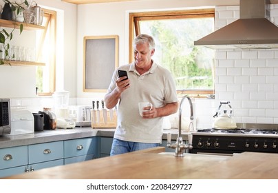 Senior man, morning coffee and phone looking happy while reading text message, online news or browsing internet in kitchen at home. Male using messenger or social media mobile app in Australia house - Powered by Shutterstock