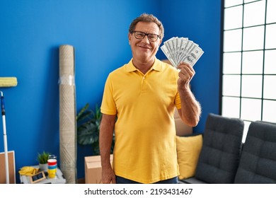 Senior Man Moving To A New Home Holding Money Looking Positive And Happy Standing And Smiling With A Confident Smile Showing Teeth 