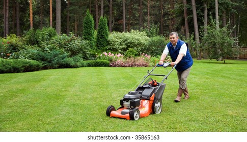 Senior Man Mowing The Lawn.