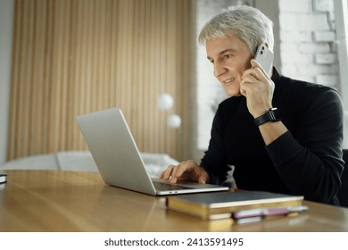 Senior man multitasking with laptop and phone call. - Powered by Shutterstock