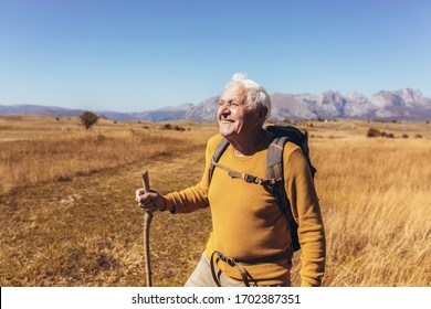 Senior Man On Hike Through Beautiful Countryside In Autumn.
