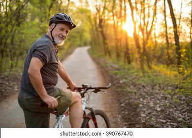 Senior man his mountain bike outdoors (shallow DOF; color toned image)