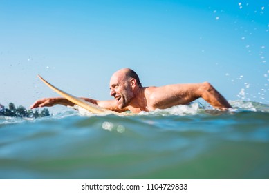 A senior man on a surfboard - Powered by Shutterstock