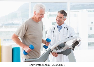 Senior Man On Treadmill With Therapist In Fitness Studio