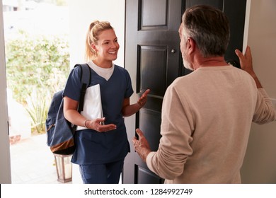 Senior man opening his front door to a female healthcare worker making a home health visit