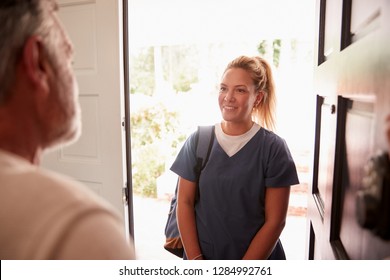 Senior man opening his front door to a female healthcare worker making a home health visit - Powered by Shutterstock