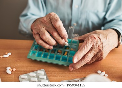 Senior Man Organizing His Medication Into Pill Dispenser. Senior Man Taking Pills From Box. Healthcare And Old Age Concept With Medicines. Medicaments On Table