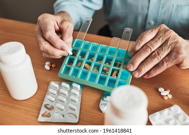 Senior Man Organizing His Medication Into Pill Dispenser. Senior Man Taking Pills From Box. Healthcare And Old Age Concept With Medicines. Medicaments On Table