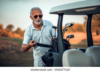 Senior Man Packs For Golf. Golf Car. 