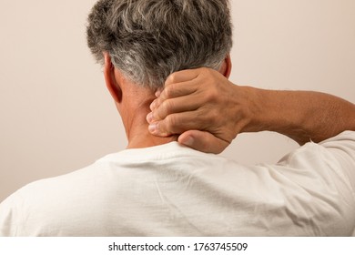 Senior Man In Pain With Headache Rubbing The Back Of His Neck For Relief 