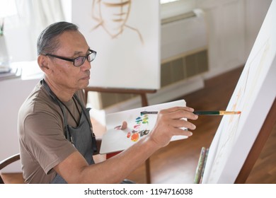 Senior Man   Painting On A Canvas At Home.portrait Of Retirement Male In Artist Studio With Painting Equipment