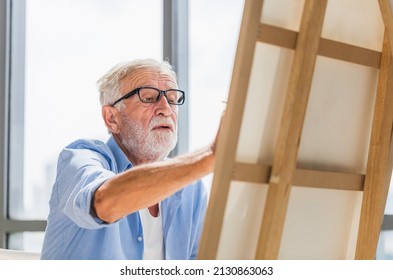 Senior man painting on canvas at home, Elderly man painting on a canvas, Happy retirement concepts - Powered by Shutterstock