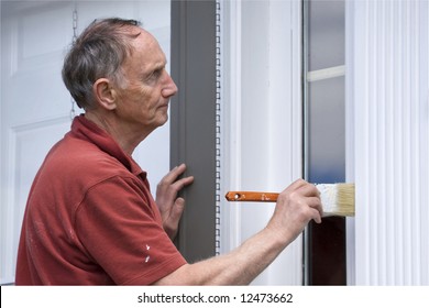 Senior Man Painting Outside Of House