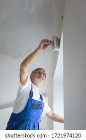 Senior Man Paintinga Room Of Rental Appartment With A Paint Bucket, Wall Painting Concept - Short Time Rental Property Maintenance