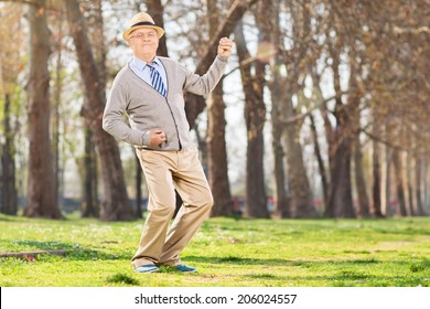 Senior man playing air guitar in the park - Powered by Shutterstock