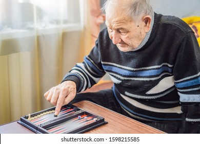 Senior man playing backgammon in a nursing home - Powered by Shutterstock