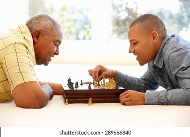 Senior Man Playing Chess With Son