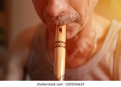 Senior Man Playing The Flute. Faceless Unprofessional Male Of Elderly Caucasian Recorder People With A Moustache With Mouth And Lips Play On Pipe Amateur Music Close Up At Home. Hobbies And Leisure