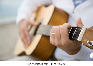 A Senior Man Playing A Guitar