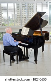 Senior Man Playing On A Grand Piano At Home