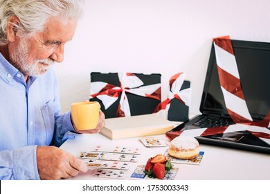 The Senior Man Plays Cards On The White Table And Takes A Break From Technology, No More Dependence On Social Media. Modern Retired Person With Hair And White Beard