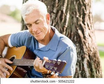 Senior Man Plying Guitar Outdoors