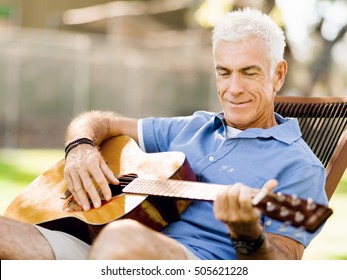 Senior Man Plying Guitar Outdoors