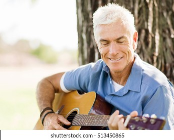 Senior Man Plying Guitar Outdoors