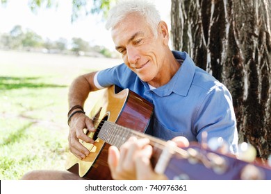 Senior Man Plying Guitar Outdoors
