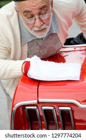 Senior Man Polishing Paintwork Of Classic Sports Car