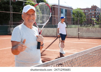 Senior man posing on tennis court - Powered by Shutterstock