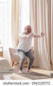 Senior Man Practicing Yoga At Home Doing Chair Pose, Utkatasana