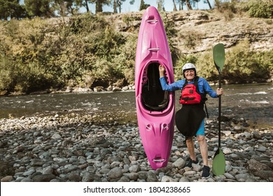 Senior man preparing for kayak tour on a mountain river. - Powered by Shutterstock