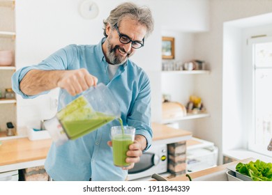 Senior Man Preparing Smoothie In Kitchen