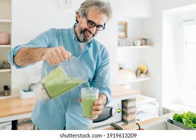 Senior man preparing smoothie in kitchen - Powered by Shutterstock