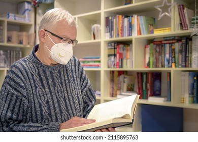 Senior Man In Protective Face Mask Browsing Books In Bookstore During Pandemic. New Normal Retail Shopping