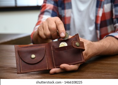 Senior Man Putting Coin Into Purse At Table, Closeup