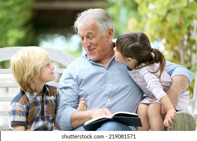 Senior Man Reading Book With Grandkids