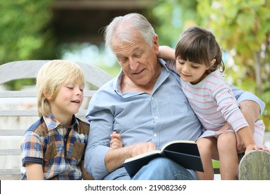 Senior Man Reading Book With Grandkids