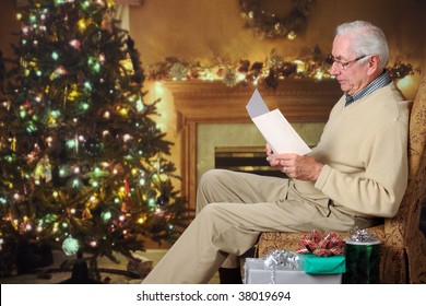 A Senior Man Reading A Card In A Living Room Decorated For Christmas.