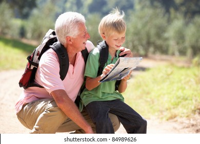 Senior man reading map with grandson on country walk - Powered by Shutterstock