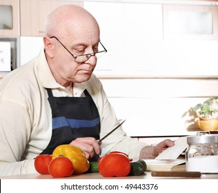 Senior Man Reading Recipe From Cookbook