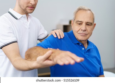 Senior man receiving a treatment of his shoulder and arm by male physio therapist
